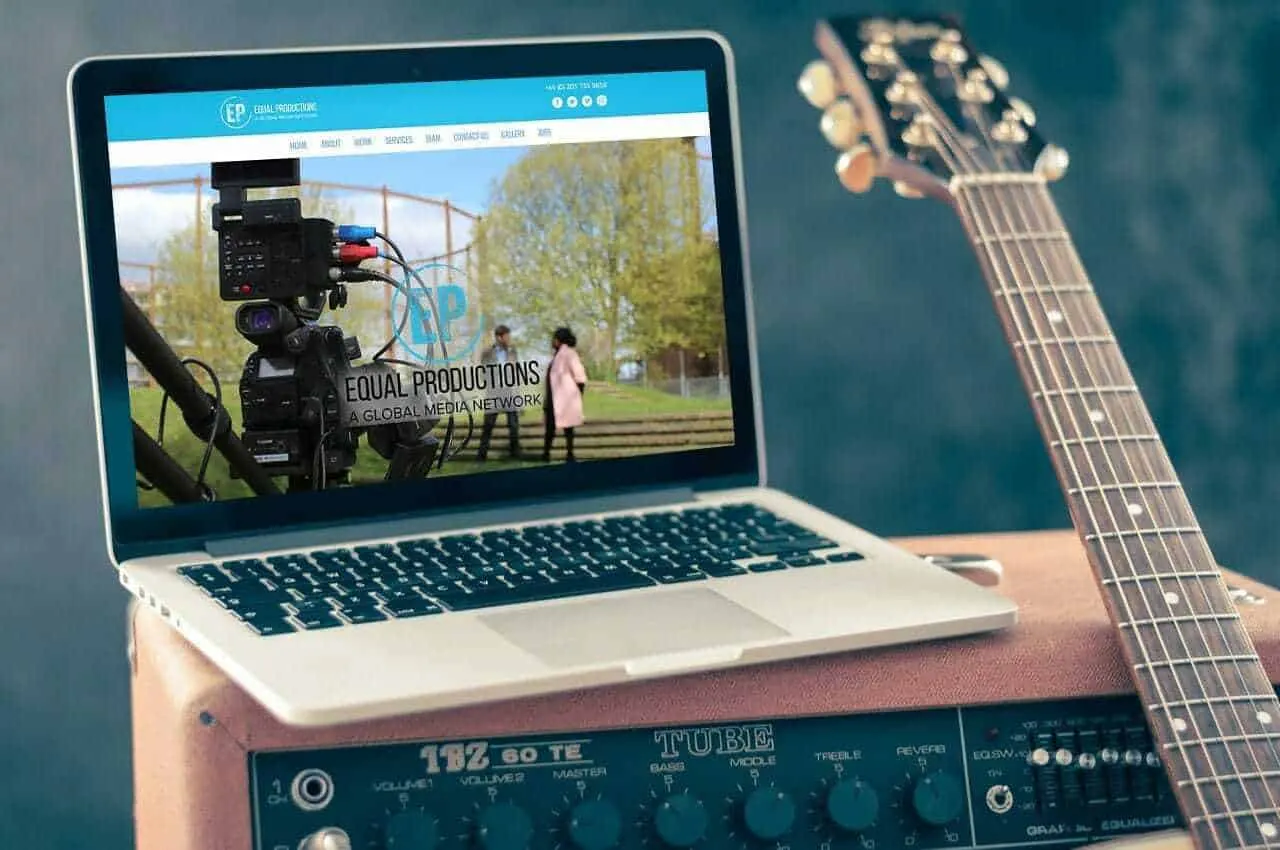 The Equal Productions site on a laptop resting on a guitar amplifier